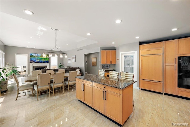 6280 Branford Dr, West Bloomfield, MI 48322 - kitchen with paneled built in fridge, a kitchen island, a fireplace, dark stone counters, and recessed lighting