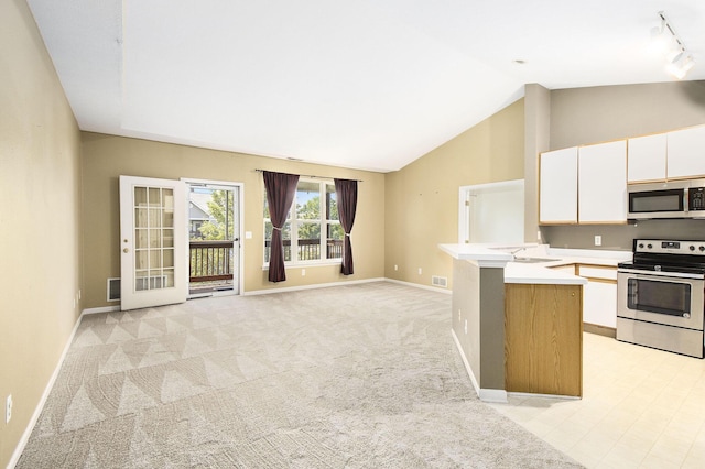 1377 Fox Pointe Cir, Ann Arbor, MI 48108 - kitchen with stainless steel appliances, light countertops, white cabinets, vaulted ceiling, and a peninsula
