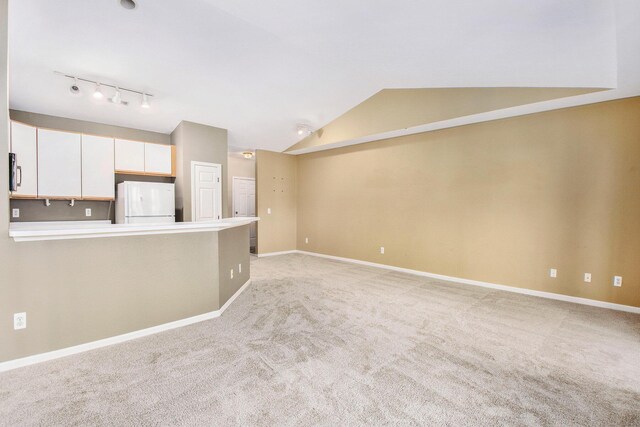 1377 Fox Pointe Cir, Ann Arbor, MI 48108 - unfurnished living room featuring track lighting, light carpet, and vaulted ceiling