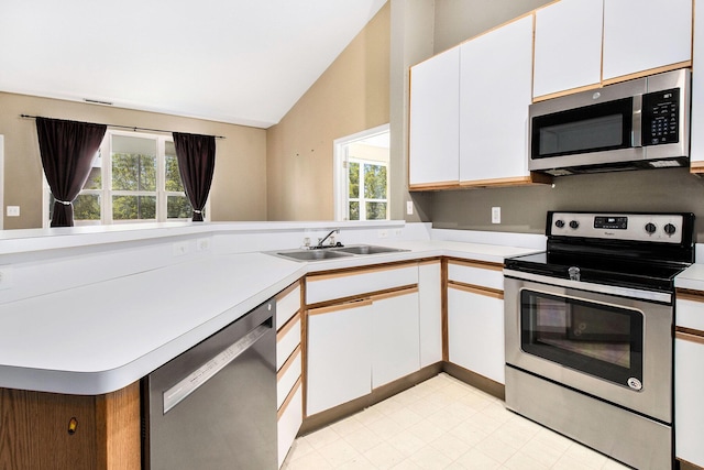 1377 Fox Pointe Cir, Ann Arbor, MI 48108 - kitchen featuring stainless steel appliances, light countertops, lofted ceiling, white cabinets, and a peninsula