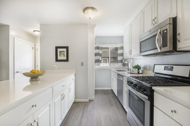 1915 Orville St SE, Grand Rapids, MI 49506 - kitchen featuring appliances with stainless steel finishes, white cabinetry, light wood-style flooring, and light countertops