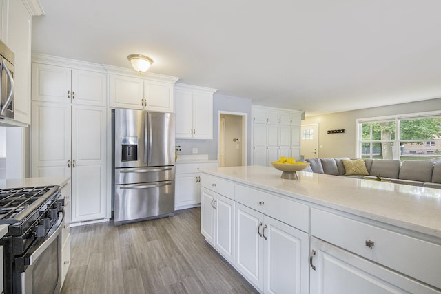1915 Orville St SE, Grand Rapids, MI 49506 - kitchen featuring stainless steel appliances, white cabinetry, light wood-type flooring, and open floor plan