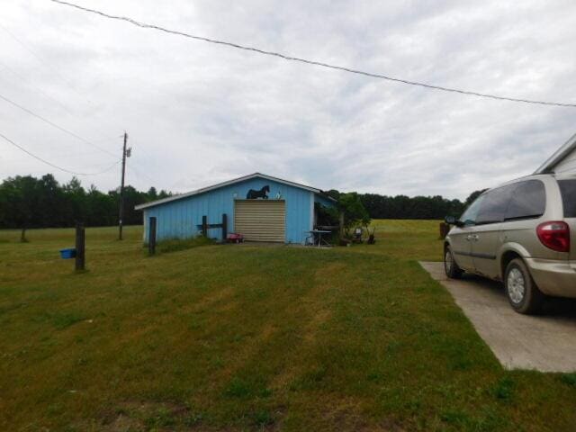 3509 E Taylor Rd, Hart, MI 49420 - view of green lawn featuring a garage, an outbuilding, and a pole building
