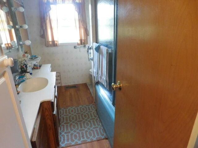 3509 E Taylor Rd, Hart, MI 49420 - full bath featuring vanity, wood finished floors, and washtub / shower combination