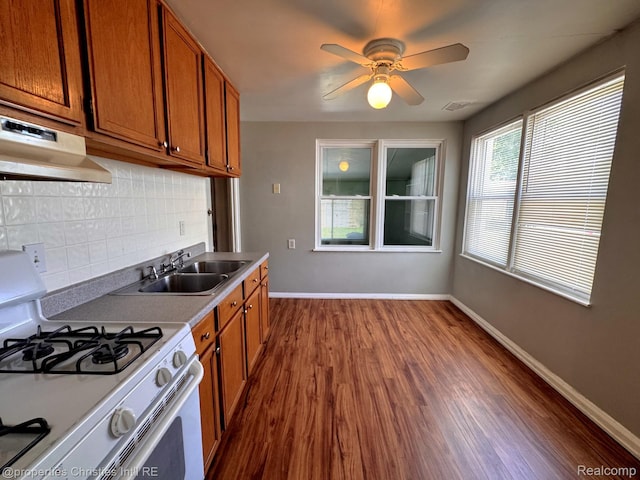 2343 Bonner St, Ferndale, MI 48220 - kitchen featuring white gas range, extractor fan, tasteful backsplash, and brown cabinets