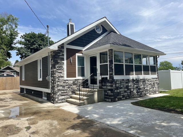 336 E Prospect St, Jackson, MI 49203 - view of front of property featuring a chimney, stone siding, and roof with shingles
