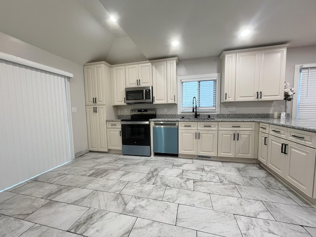 336 E Prospect St, Jackson, MI 49203 - kitchen featuring stainless steel appliances, lofted ceiling, light stone counters, light marble finish flooring, and recessed lighting