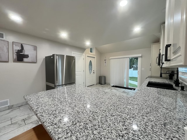 336 E Prospect St, Jackson, MI 49203 - kitchen featuring stainless steel appliances, white cabinets, a peninsula, light stone countertops, and recessed lighting