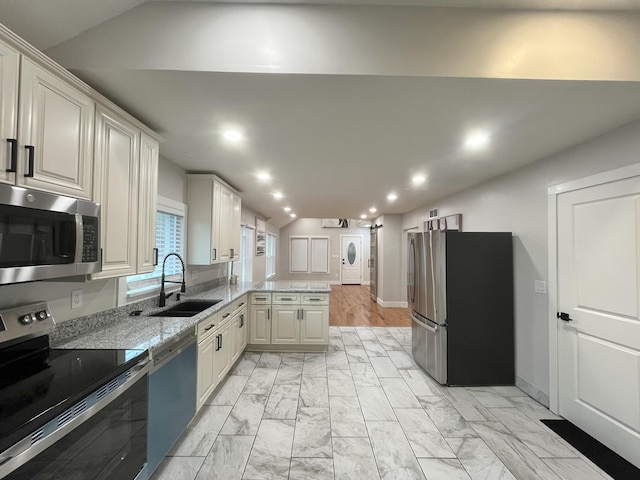 336 E Prospect St, Jackson, MI 49203 - kitchen with appliances with stainless steel finishes, a peninsula, light marble finish floors, light stone counters, and recessed lighting