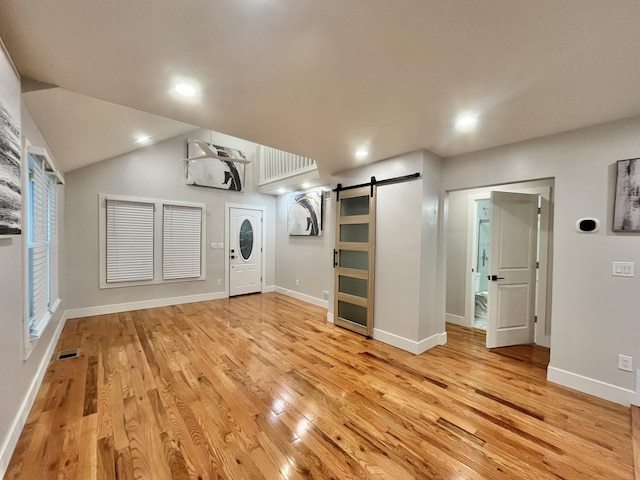 336 E Prospect St, Jackson, MI 49203 - unfurnished living room with a barn door, light wood-style flooring, recessed lighting, and lofted ceiling