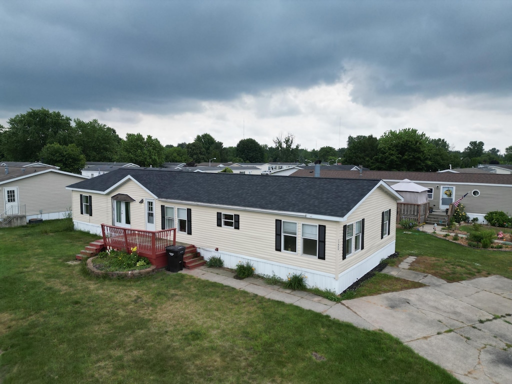 11400 Caberfae Ave, Allendale, MI 49401 - manufactured / mobile home with roof with shingles, a front yard, and a deck