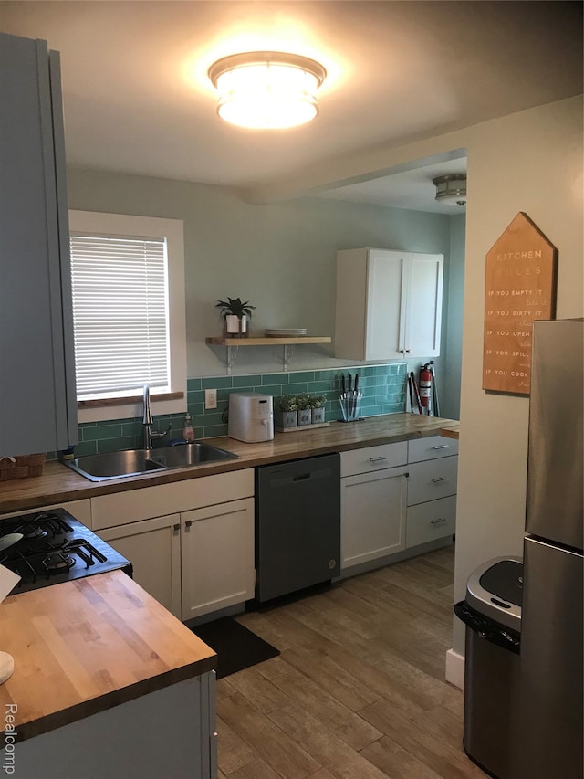 18522 Joseph Campau St, Detroit, MI 48234 - kitchen featuring dishwashing machine, white cabinets, freestanding refrigerator, and wood finished floors