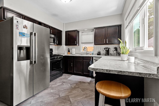 1426 Lancashire SE, Grand Rapids, MI 49508 - kitchen featuring stainless steel appliances, healthy amount of natural light, dark brown cabinetry, and light countertops