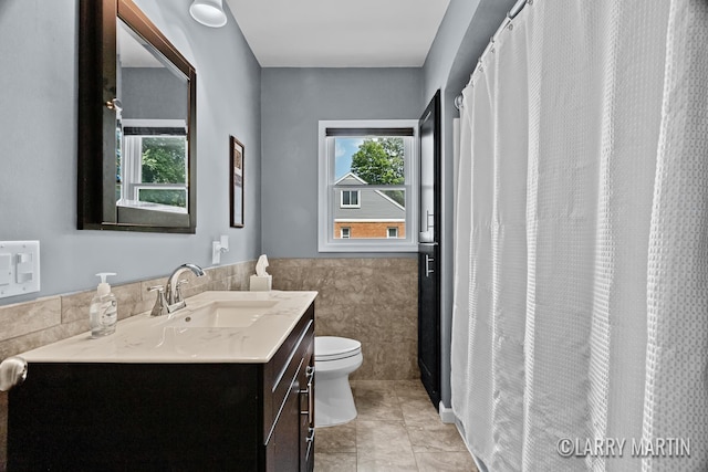 1426 Lancashire SE, Grand Rapids, MI 49508 - full bathroom with tile walls, vanity, healthy amount of natural light, a wainscoted wall, and tile patterned floors