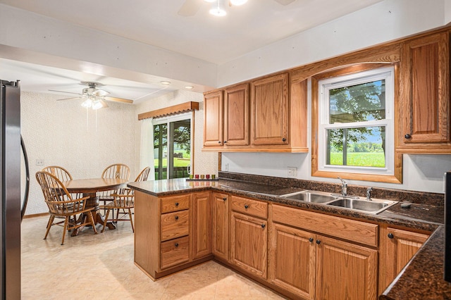 18169 6th Avenue Rd, Three Rivers, MI 49093 - kitchen featuring a ceiling fan, freestanding refrigerator, plenty of natural light, and brown cabinetry