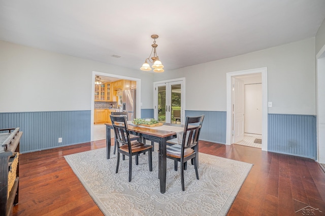 8603 Millington Rd, Vassar, MI 48768 - dining room featuring wainscoting, french doors, hardwood / wood-style flooring, and a chandelier