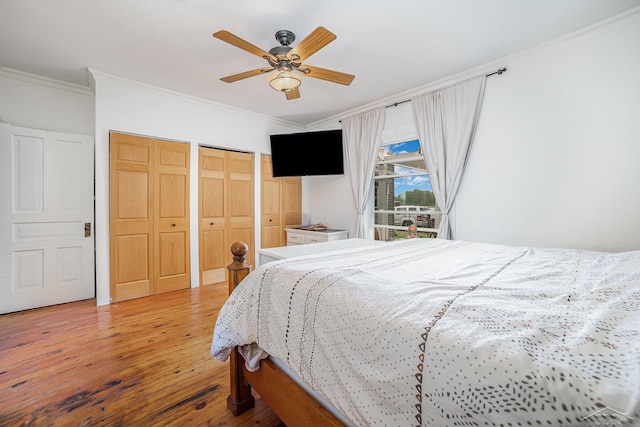 8603 Millington Rd, Vassar, MI 48768 - bedroom featuring ornamental molding, wood-type flooring, two closets, and a ceiling fan