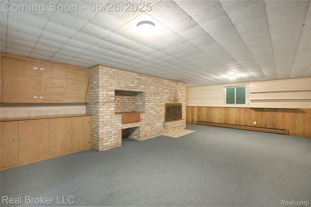 5492 N Sycamore Dr, Burton, MI 48509 - unfurnished living room with a baseboard radiator, carpet flooring, wood walls, and a fireplace