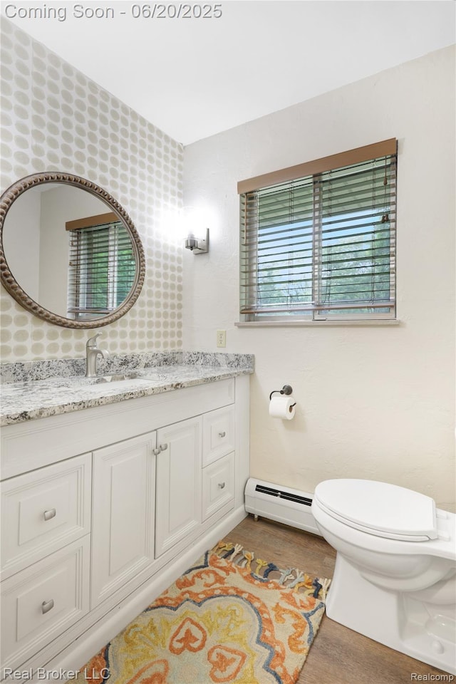 5492 N Sycamore Dr, Burton, MI 48509 - half bathroom featuring baseboard heating, vanity, and wood finished floors