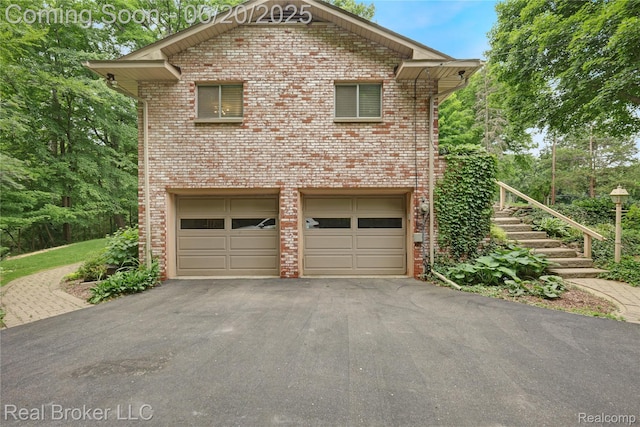 5492 N Sycamore Dr, Burton, MI 48509 - view of home's exterior with asphalt driveway, an attached garage, brick siding, and stairs