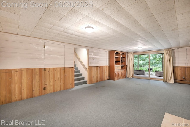 5492 N Sycamore Dr, Burton, MI 48509 - empty room featuring wood walls, carpet, stairs, and wainscoting