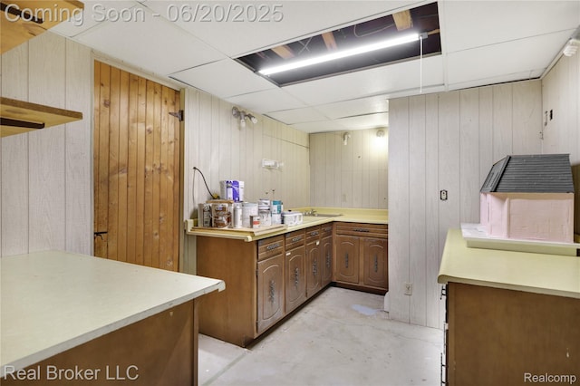 5492 N Sycamore Dr, Burton, MI 48509 - kitchen with concrete flooring, wood walls, and light countertops