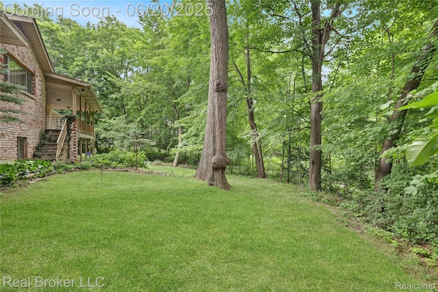 5492 N Sycamore Dr, Burton, MI 48509 - view of green lawn with stairs and a forest view
