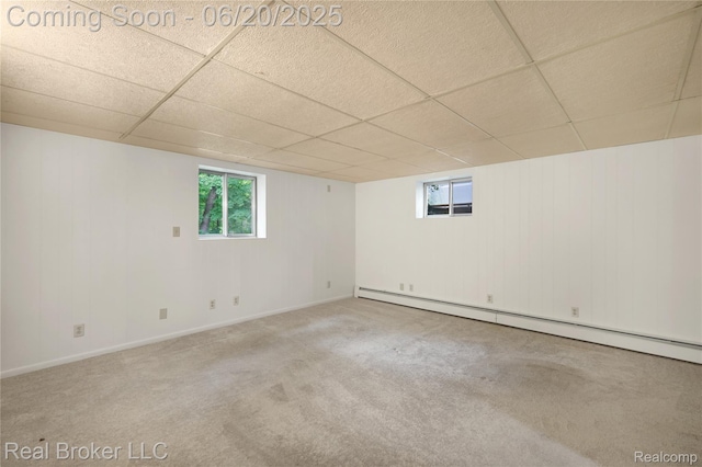 5492 N Sycamore Dr, Burton, MI 48509 - empty room with a baseboard heating unit, a drop ceiling, carpet floors, and wooden walls