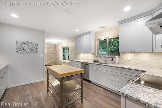 5492 N Sycamore Dr, Burton, MI 48509 - kitchen with stainless steel dishwasher, wall chimney exhaust hood, tasteful backsplash, wood finished floors, and recessed lighting
