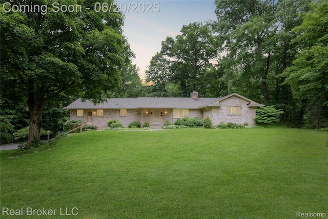 5492 N Sycamore Dr, Burton, MI 48509 - single story home featuring a chimney, a front yard, and brick siding