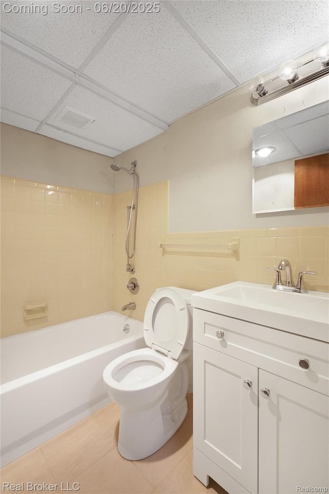 5492 N Sycamore Dr, Burton, MI 48509 - full bathroom with vanity, a paneled ceiling, bathing tub / shower combination, tile patterned floors, and tile walls