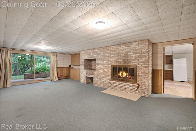 5492 N Sycamore Dr, Burton, MI 48509 - unfurnished living room featuring carpet floors, a fireplace, and wooden walls