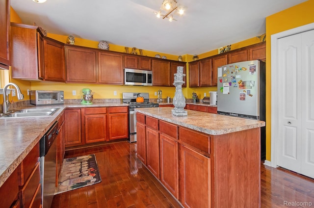 15740 Aspen Dr, Romulus, MI 48174 - kitchen with stainless steel appliances, dark wood finished floors, light countertops, a kitchen island, and brown cabinets