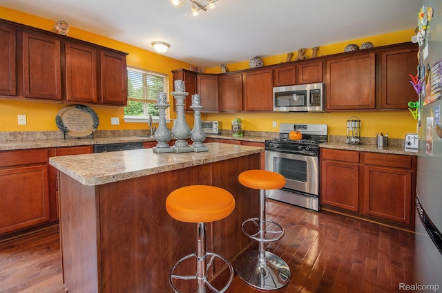 15740 Aspen Dr, Romulus, MI 48174 - kitchen featuring stainless steel appliances, a center island, light countertops, a kitchen breakfast bar, and dark wood finished floors