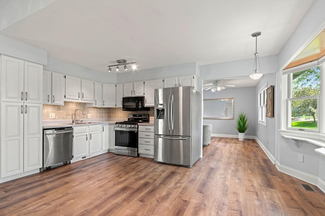 749 Foxboro Ct, Saline, MI 48176 - kitchen with appliances with stainless steel finishes, white cabinets, dark wood-style flooring, and tasteful backsplash