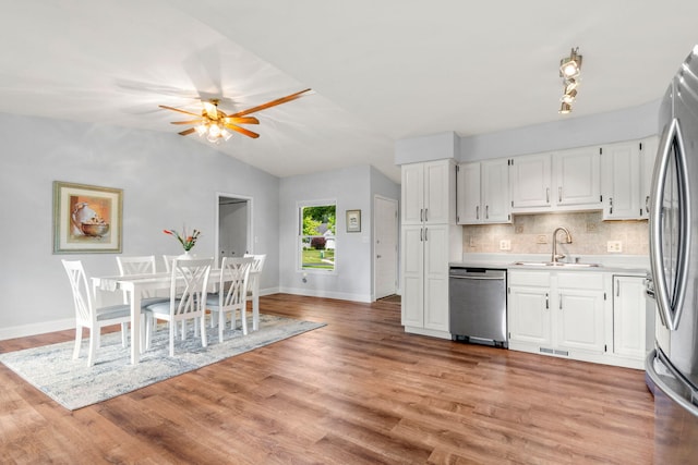 749 Foxboro Ct, Saline, MI 48176 - kitchen with stainless steel appliances, light countertops, a ceiling fan, white cabinets, and backsplash