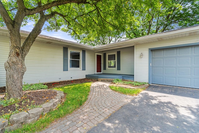 749 Foxboro Ct, Saline, MI 48176 - view of exterior entry featuring an attached garage, asphalt driveway, and a porch