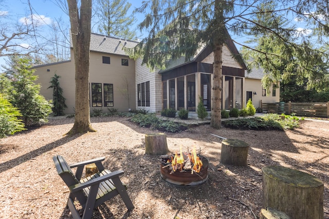 9435 Community Hall Rd, Union Pier, MI 49129 - back of property with an outdoor fire pit, a sunroom, and a shingled roof