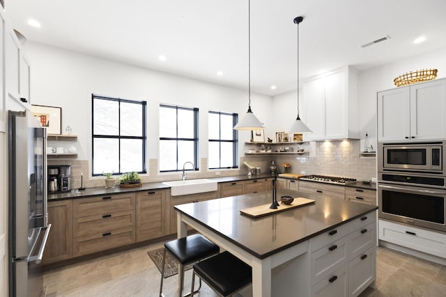 9435 Community Hall Rd, Union Pier, MI 49129 - kitchen with appliances with stainless steel finishes, open shelves, dark countertops, backsplash, and recessed lighting