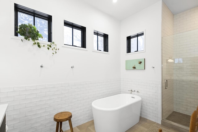 9435 Community Hall Rd, Union Pier, MI 49129 - full bath with tile walls, a freestanding tub, a stall shower, vanity, and wainscoting