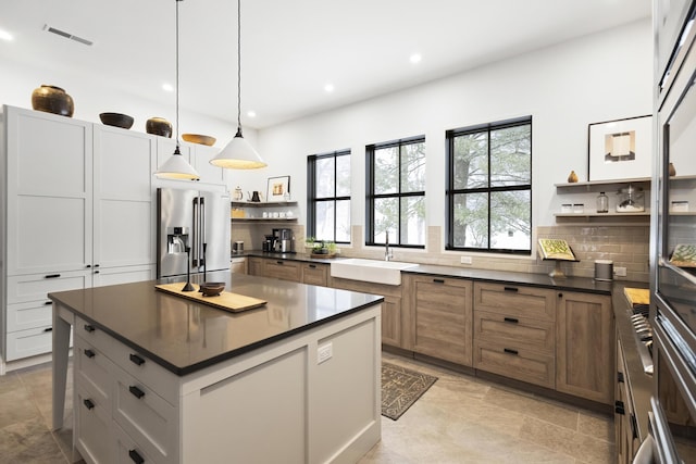 9435 Community Hall Rd, Union Pier, MI 49129 - kitchen featuring stainless steel fridge, open shelves, dark countertops, decorative backsplash, and recessed lighting