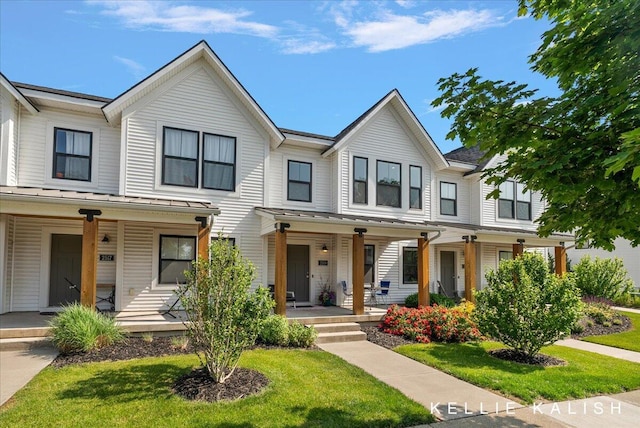 2519 Inverness Rd SE, Grand Rapids, MI 49546 - multi unit property featuring covered porch, a standing seam roof, a front yard, and a metal roof
