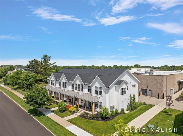 2519 Inverness Rd SE, Grand Rapids, MI 49546 - view of front of home with a porch, a front yard, a metal roof, a standing seam roof, and concrete driveway