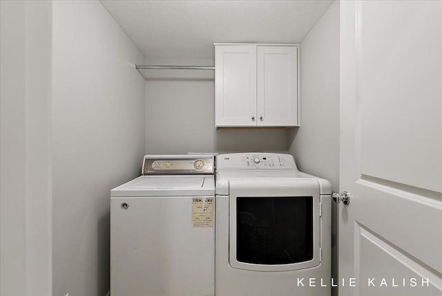 2519 Inverness Rd SE, Grand Rapids, MI 49546 - laundry room featuring washing machine and clothes dryer, cabinet space, and a textured ceiling