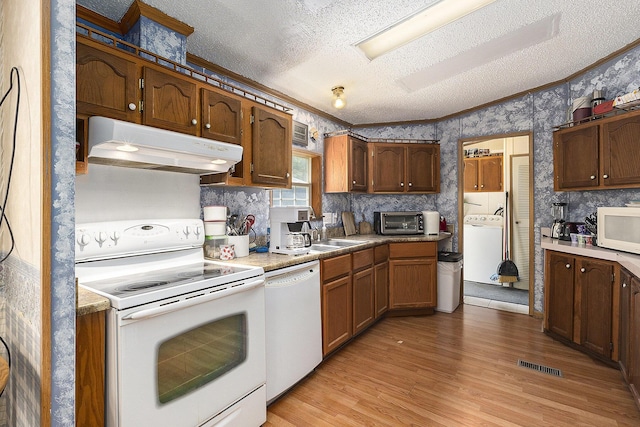 720 S 72nd Ave, Shelby, MI 49455 - kitchen with white appliances, under cabinet range hood, a textured ceiling, washer / clothes dryer, and wallpapered walls