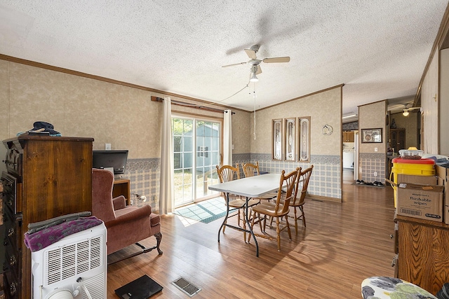 720 S 72nd Ave, Shelby, MI 49455 - dining space featuring a ceiling fan, crown molding, a wainscoted wall, wood finished floors, and wallpapered walls