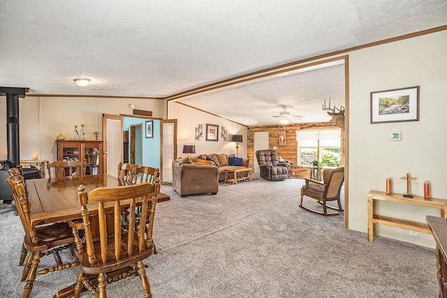 4890 W Birch Ln, Pentwater, MI 49449 - carpeted dining room with a textured ceiling, ornamental molding, ceiling fan, a wood stove, and wood walls