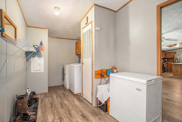 4890 W Birch Ln, Pentwater, MI 49449 - laundry room with cabinet space, washer and clothes dryer, a textured ceiling, ornamental molding, and wood finished floors