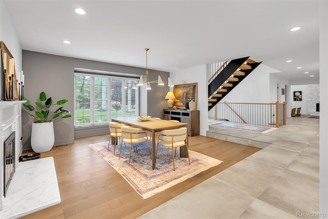 163 Manorwood Dr, Bloomfield Hills, MI 48304 - dining room featuring a fireplace, stairs, recessed lighting, a chandelier, and light wood-style flooring