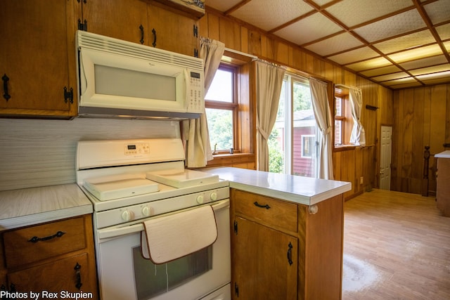 3193 W 112th St, Grant, MI 49327 - kitchen with white appliances, light countertops, a peninsula, wooden walls, and brown cabinets